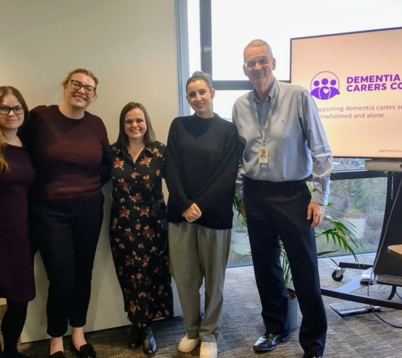Five staff from Dementia Carers Count and FSB Insurance Service stand together smiling.