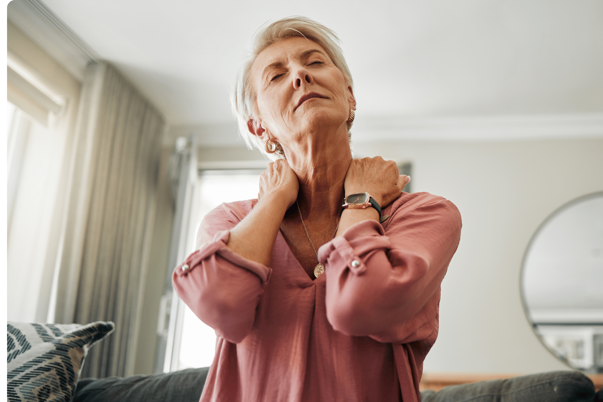 A woman is rubbing her shoulders and looks tired and in discomfort. She has no time to look after her health needs.